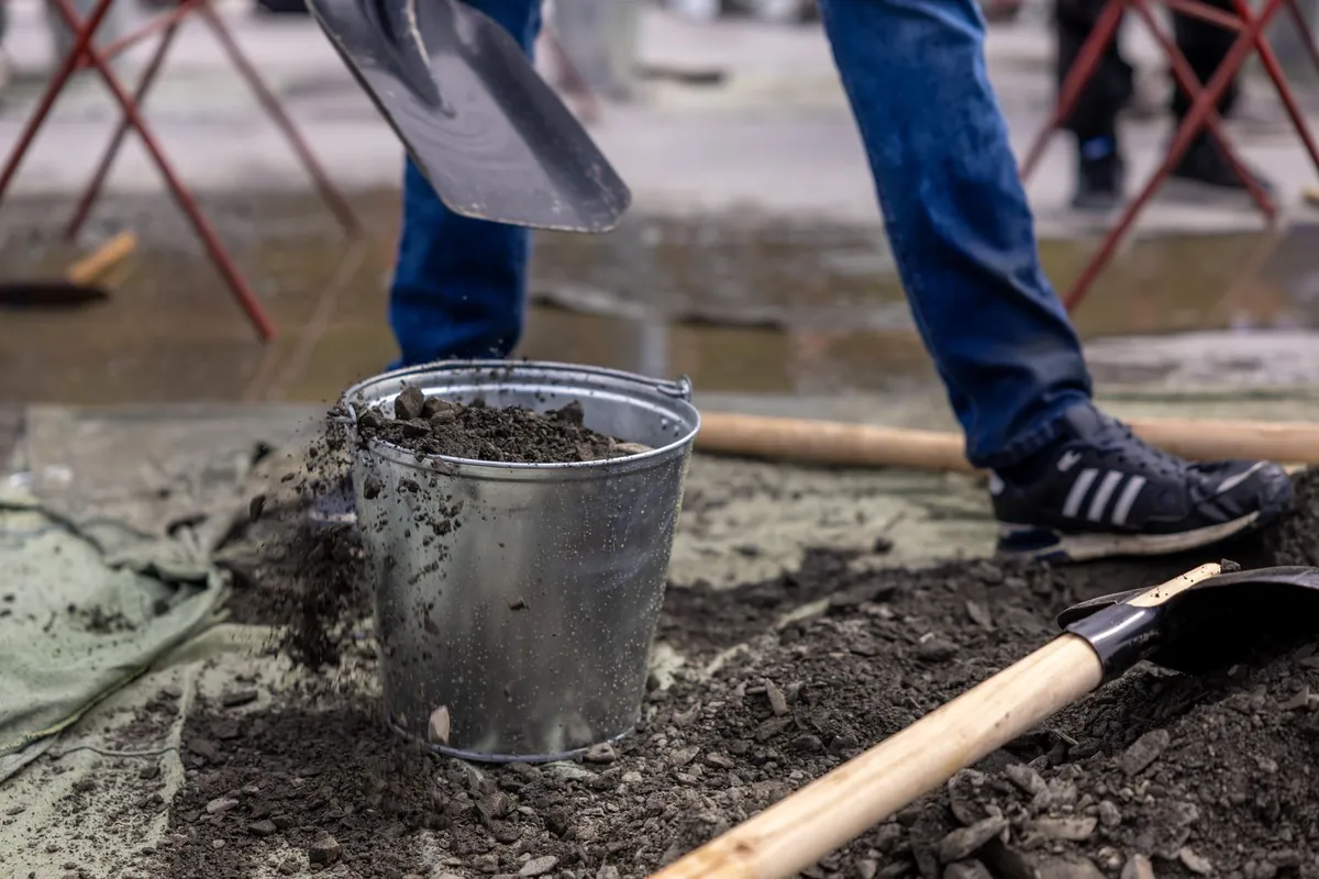 Worker digging soil with a shovel, the kind of excavation done for septic repairs near Chalfont, PA